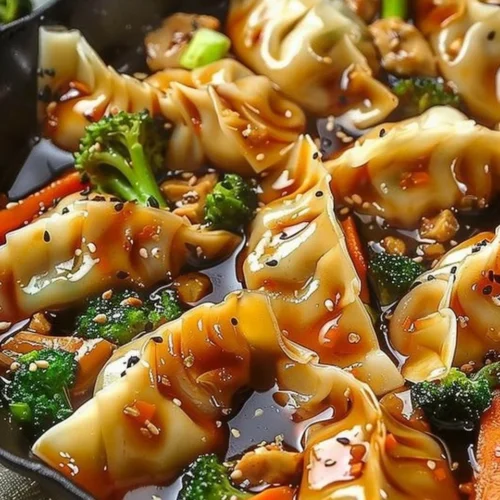 Colorful potsticker stir fry with vegetables and sauce in a skillet