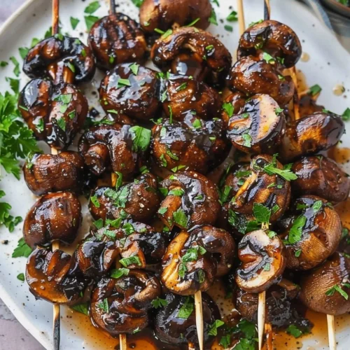 Smoky grilled balsamic and garlic marinated mushroom skewers on a plate.
