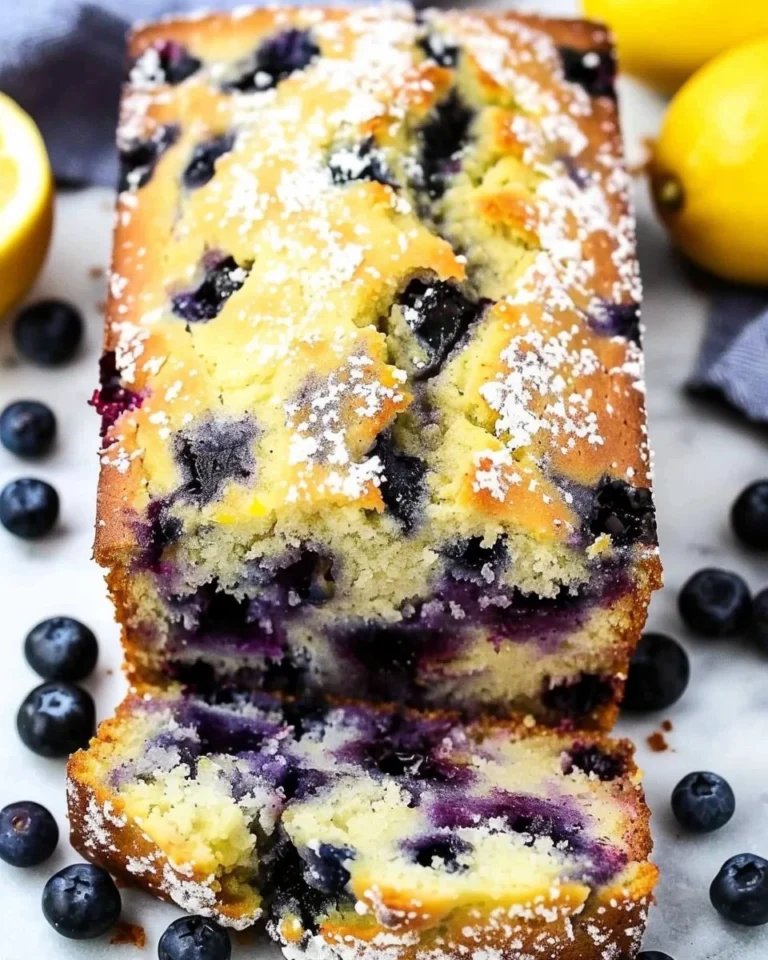 A freshly baked loaf of Lemon Blueberry Bread with vibrant blueberries and lemon zest.